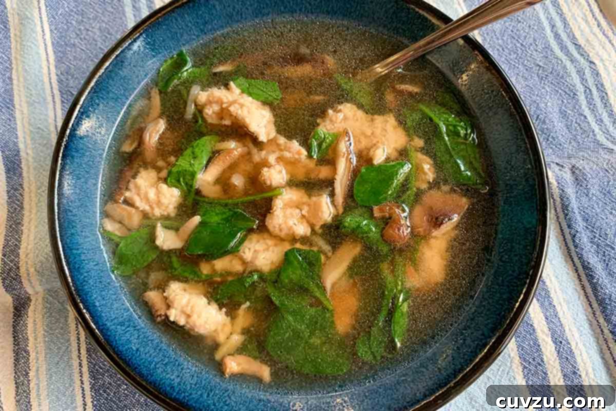 Silken Chicken and Spinach Velouté 5 A blue bowl filled with velvet chicken and spinach soup, ready to be enjoyed.