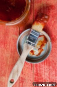A basting brush covered in rich, dark chipotle maple barbecue sauce, perfect for grilling.