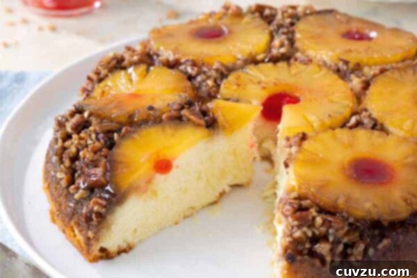 A pineapple upside-down cake on a white plate with a slice taken out