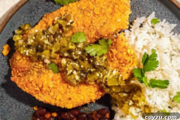 Air fryer tilapia with tortilla crust on a plate with rice and beans