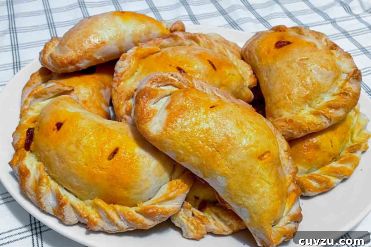 Classic Chilean Beef Empanadas 5 A pile of Chilean meat empanadas on a white plate