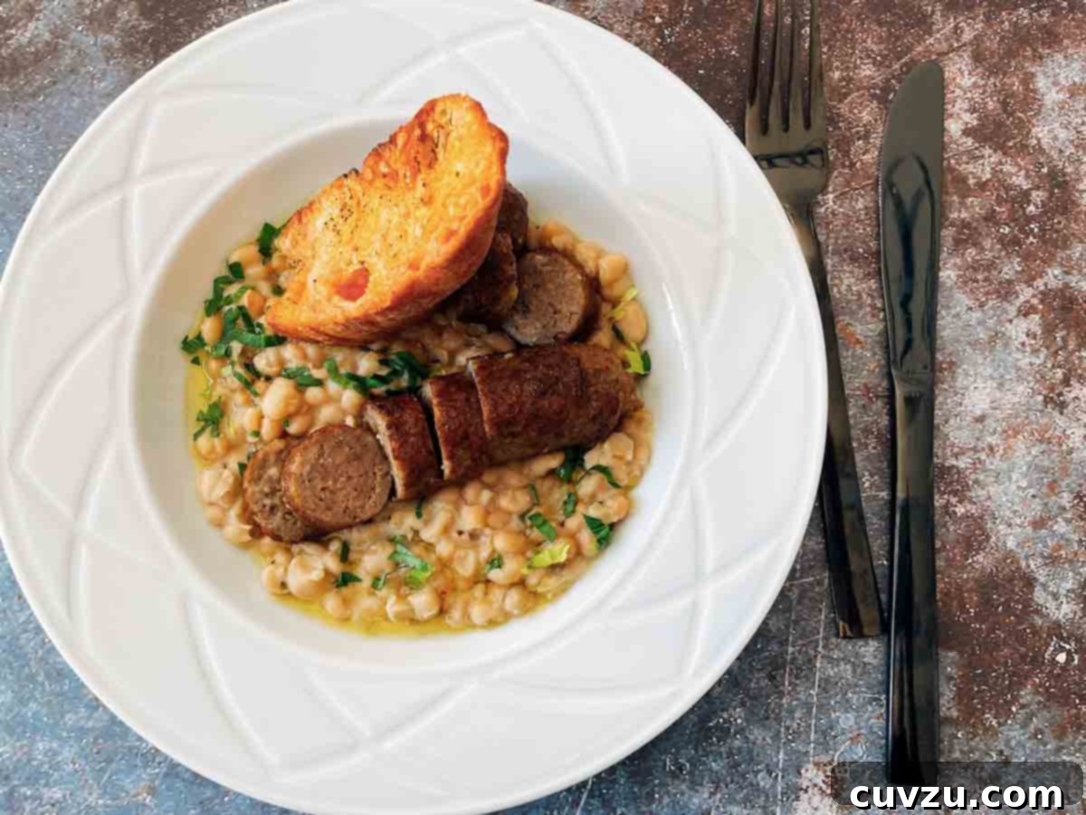 A white bowl filled with cannellini beans, parsley, toasted bread, and a cooked homemade Spanish sausage