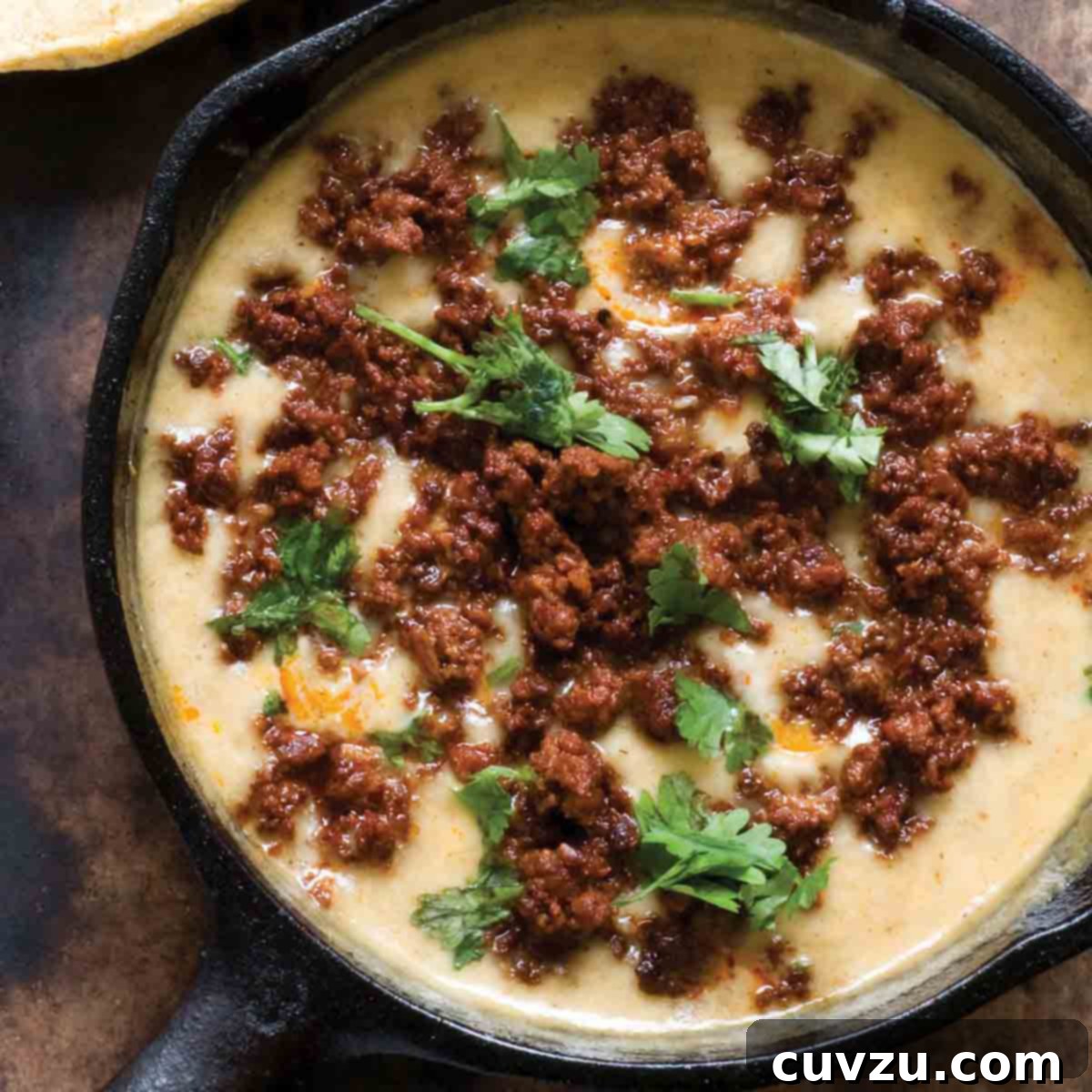 Cinco de Mayo Feast: Over 30 Delicious Recipes 7 A cast-iron skillet filled with bubbling choriqueso, a rich Mexican cheese dip generously topped with cooked chorizo sausage and fresh cilantro.