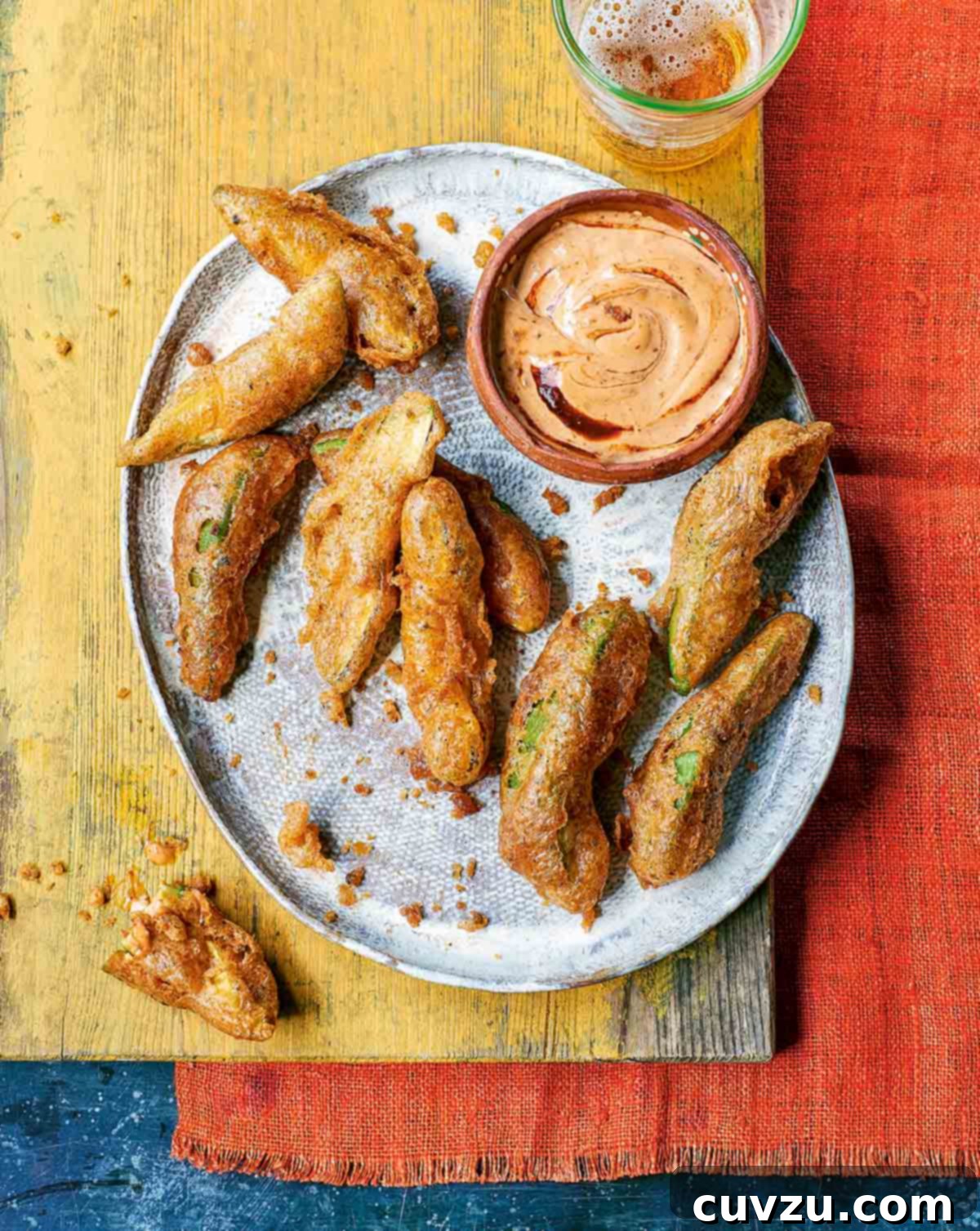 Cinco de Mayo Feast: Over 30 Delicious Recipes 9 A silver platter showcasing nine golden-fried avocado dippers, perfectly crispy and served alongside a small dish of creamy chipotle dipping sauce.