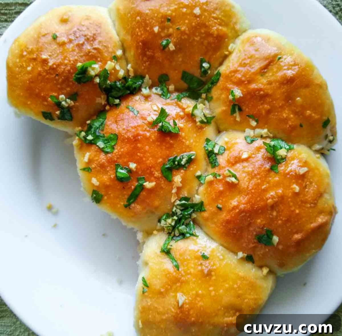 Pampushky Ukrainian Garlic Bread 10 A round plate filled with beautifully golden Ukrainian garlic bread rolls, glistening with garlic-parsley oil.