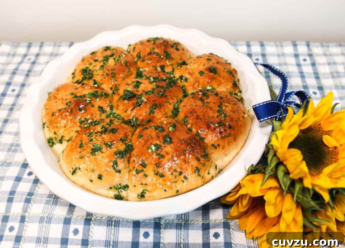 Pampushky Ukrainian Garlic Bread 5 Eight Ukrainian garlic bread rolls on a white plate with a bunch of sunflowers on the side, evoking a sense of Ukrainian pride and culinary tradition.