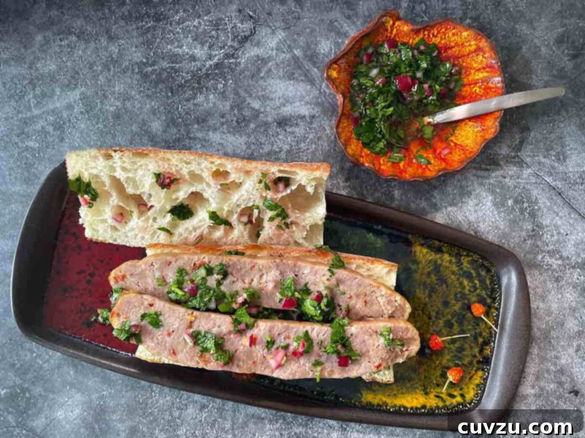 Air Fryer Sausage Sensation 5 A cooked chicken and turkey mix sausage, halved lengthwise on a toasted bun, garnished with fresh chimichurri and a side of cherry tomato salad.