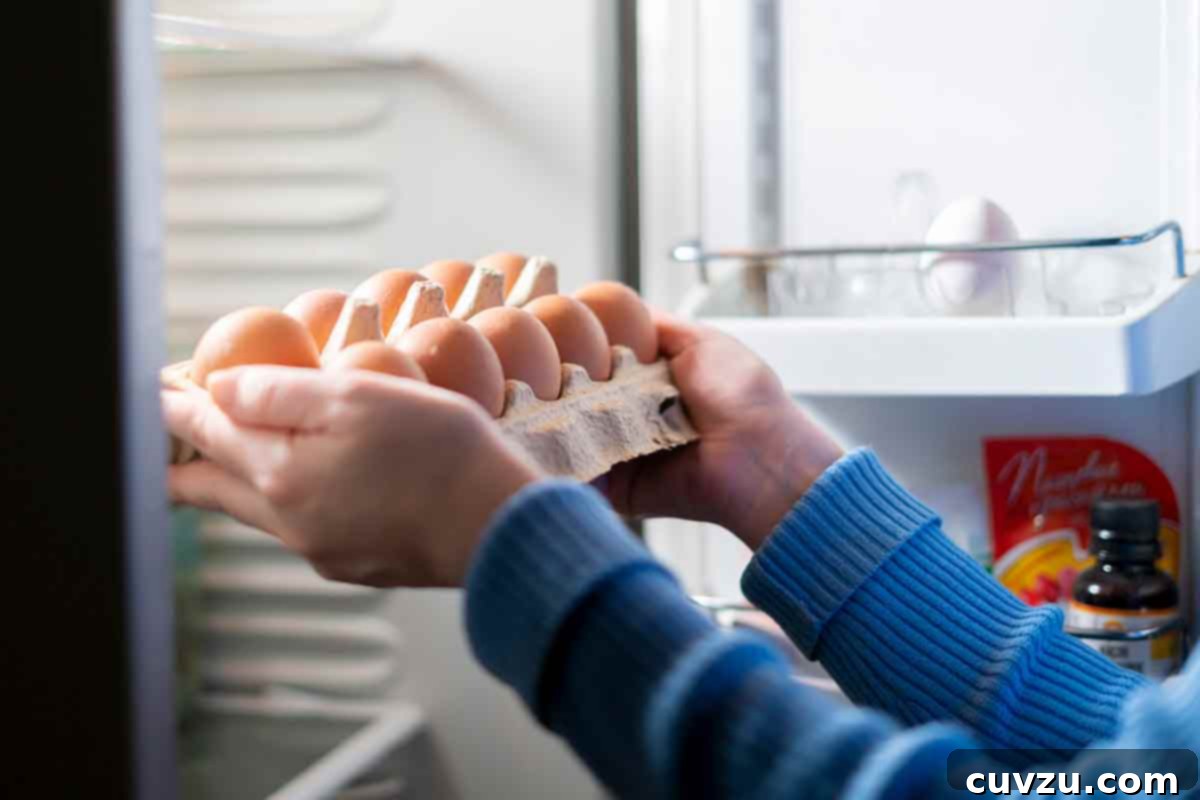 Your Ultimate Guide to Eggs 4 A woman placing a dozen raw eggs in the refrigerator