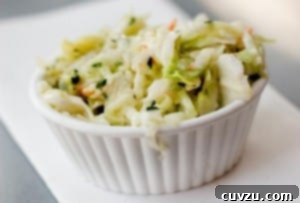Small white ramekin filled with coleslaw with maple syrup