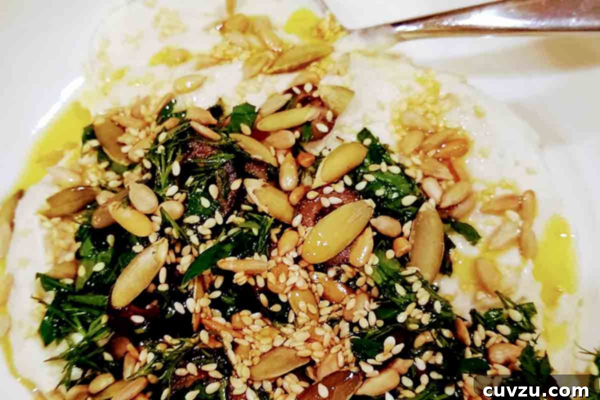 Creamy White Bean Dip 6 A bowl of white bean hummus topped with seeds and parsley and oil
