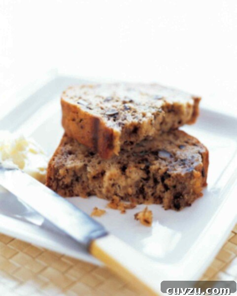 A broken slice of banana bread stacked on a white plate