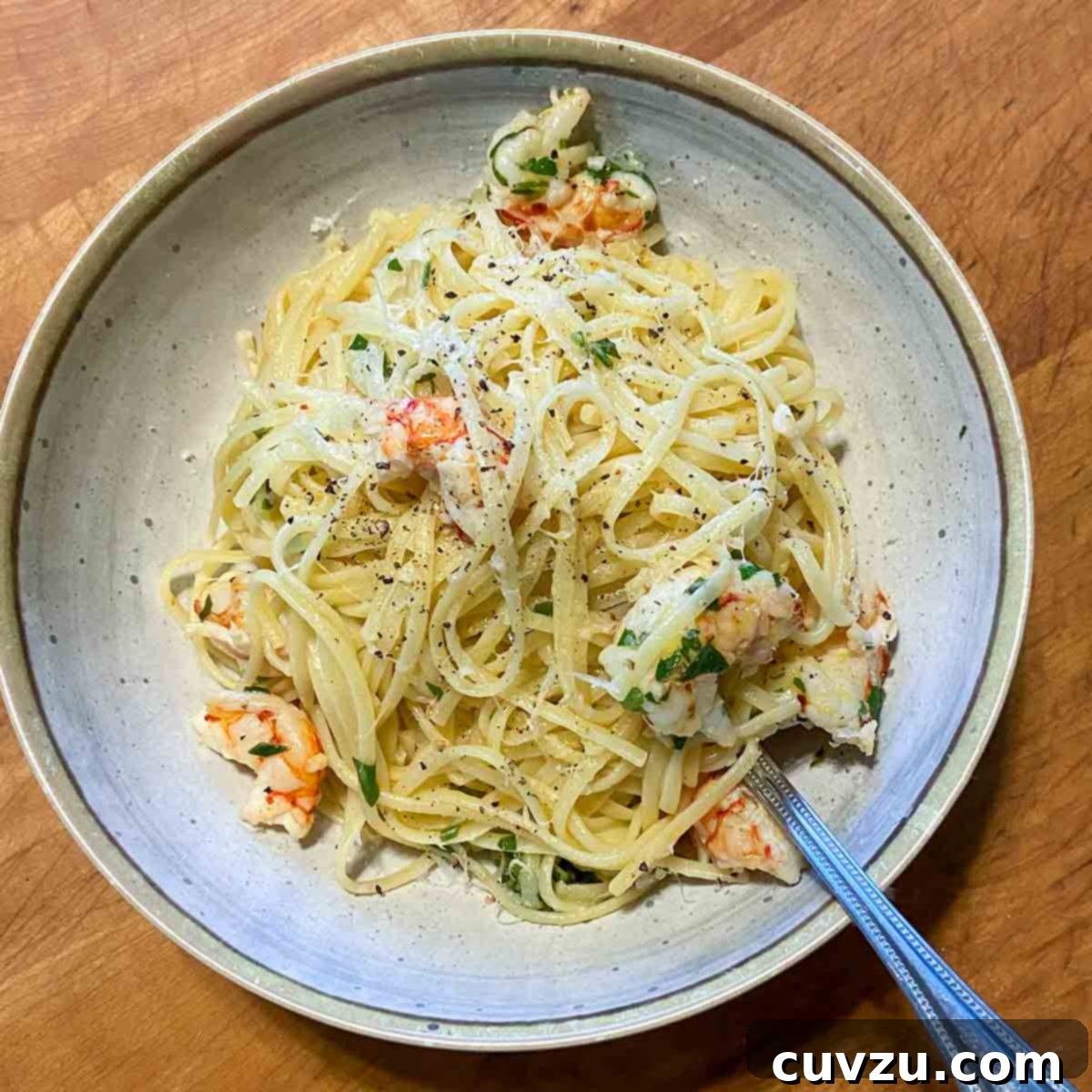 Zesty Lemon Garlic Shrimp Pasta 6 A pasta bowl filled with lemon garlic shrimp pasta an a fork resting inside the pasta.