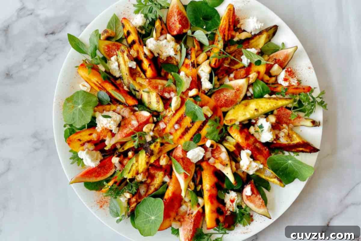 A grilled avocado and peach salad with goat cheese and figs on a round white platter, ready to be served.