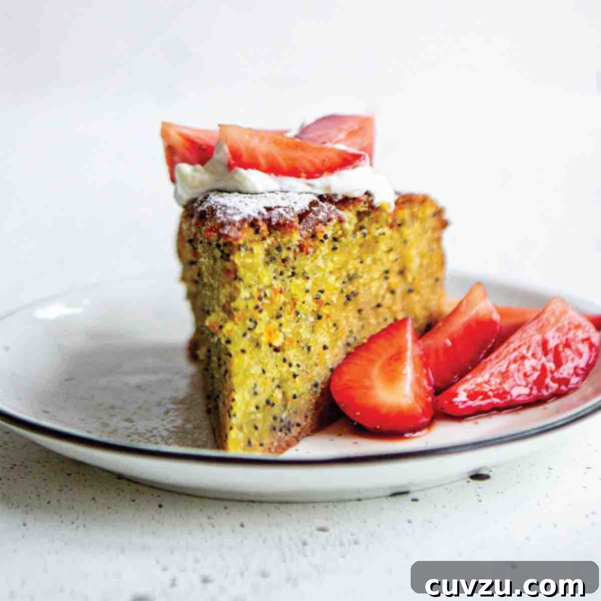 6 Irresistible Snacking Cakes You Need to Try 3 A slice of orange, olive oil, and poppyseed cake with sliced strawberries on the side on a white plate. A perfect Mediterranean-inspired dessert.