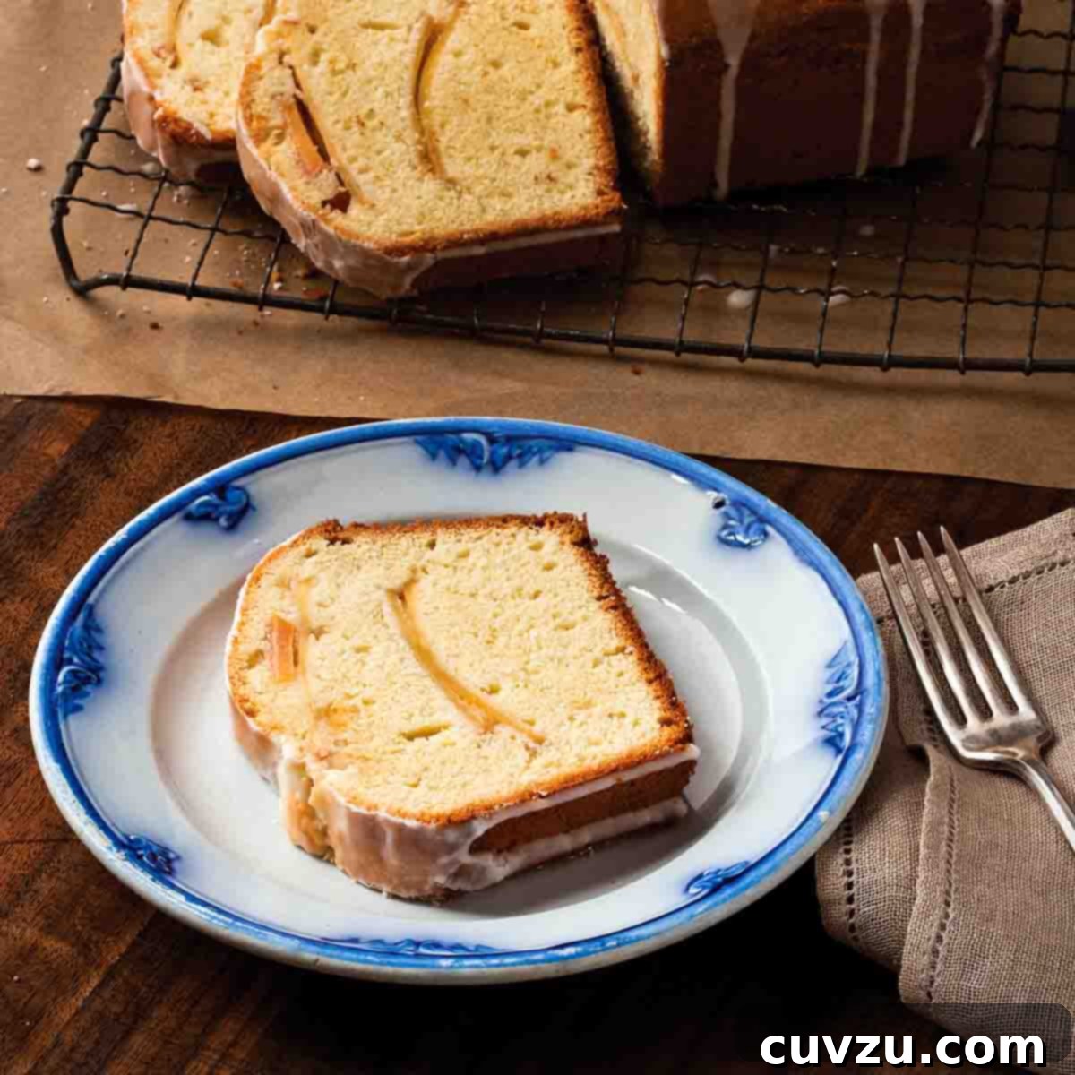 6 Irresistible Snacking Cakes You Need to Try 6 A sliced apple tea cake on a wire rack, with one slice on a blue and white patterned plate with a fork on the side. A heartwarming apple tea cake.