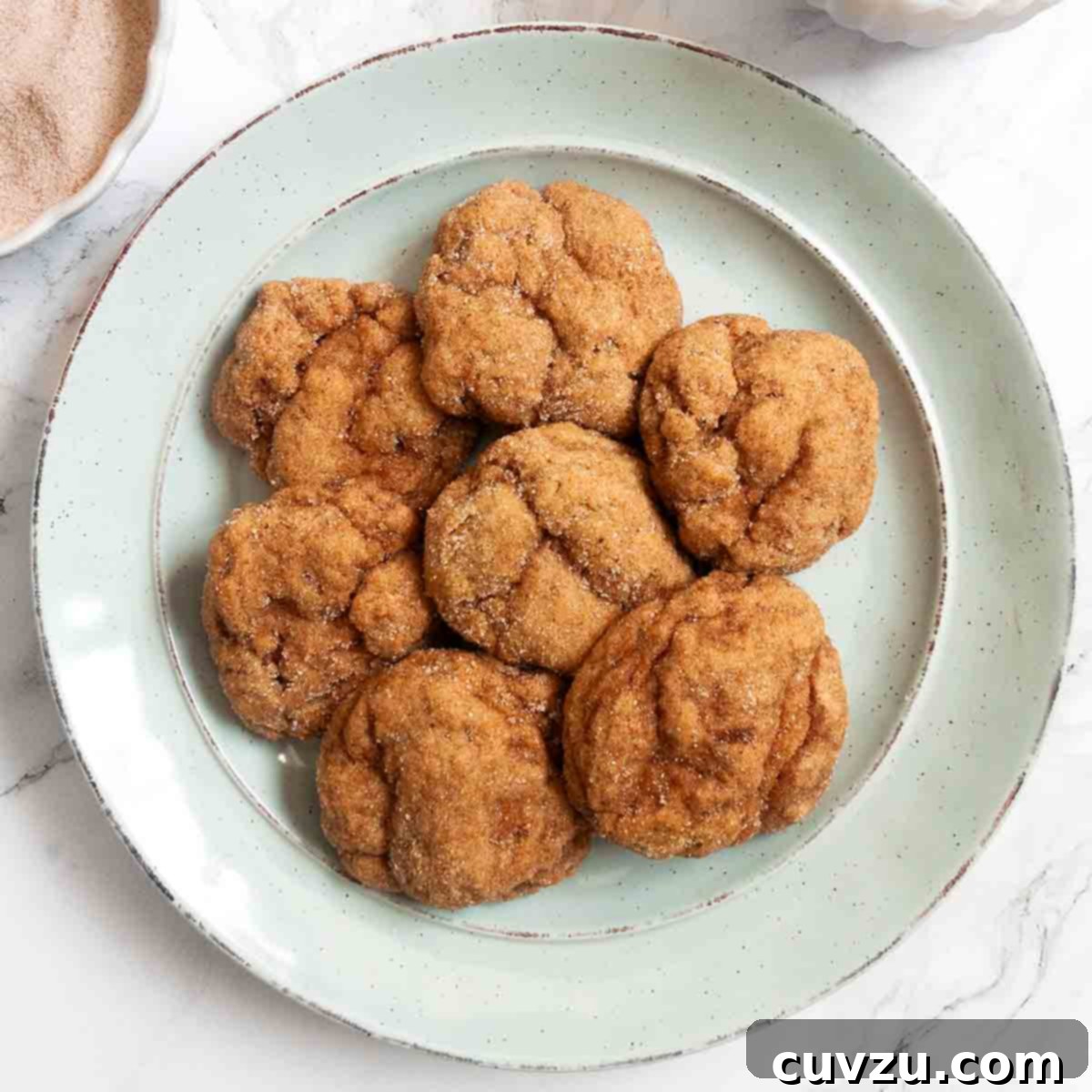 Seven pumpkin spice cookies on a green plate.