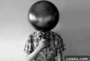 A person holding a wok for making wok popcorn in front of their face.
