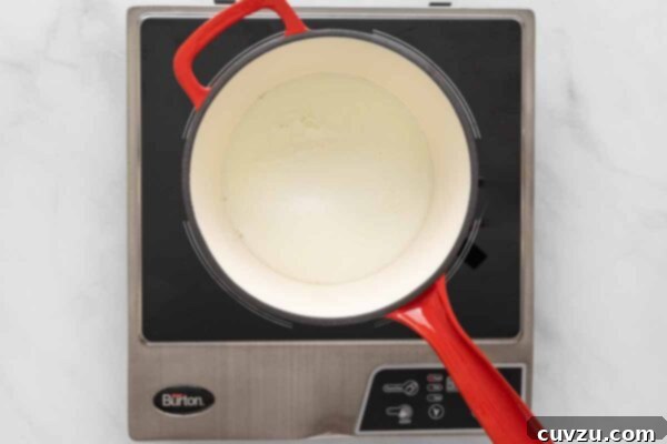 Golden Cheddar Drizzle 11 Milk heating in a saucepan.