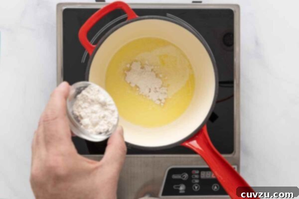 Golden Cheddar Drizzle 12 Flour being added to melted butter in a saucepan.