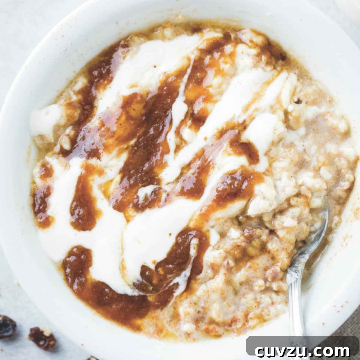A bowl of cinnamon roll oatmeal with brown sugar swirl and yogurt drizzled over the top.