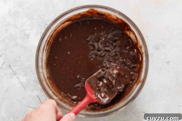 Irresistible Chocolate Muffins 16 Chocolate pieces being stirred into muffin batter.