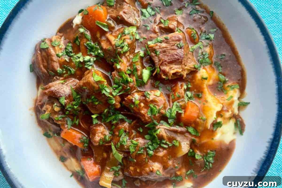 Hearty Slow Cooker Irish Beef Stew 6 A bowl of beef stew and mashed potatoes.