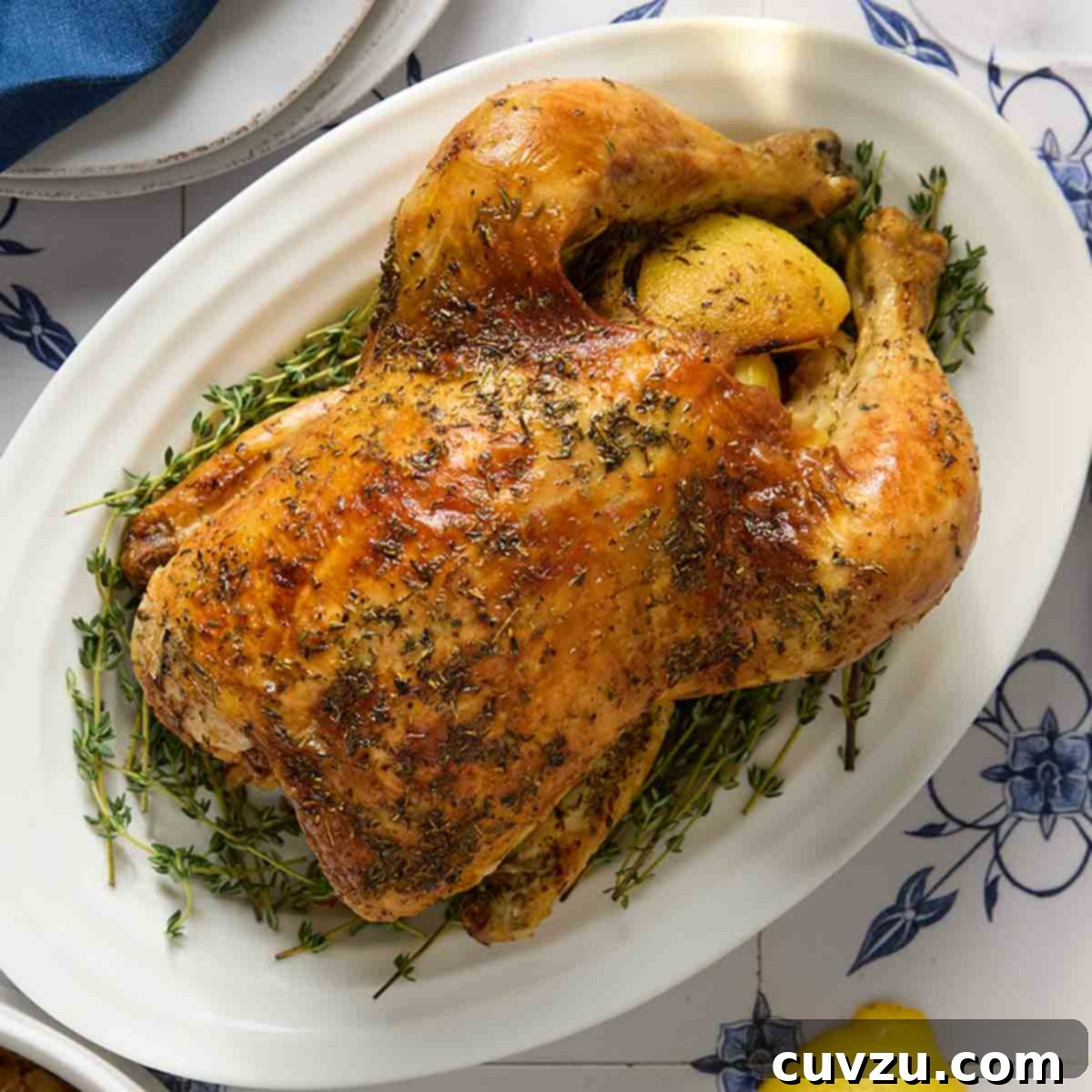 13 Recipes to Make Mom's Day Unforgettable 10 A whole roast chicken on a platter with a bowl.