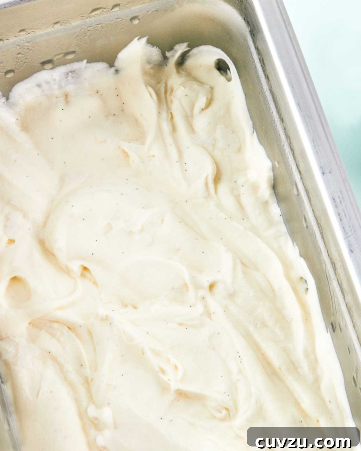 Sweet Six No-Churn Ice Cream Treats 3 A close-up of vanilla ice cream in a metal pan on a blue background.