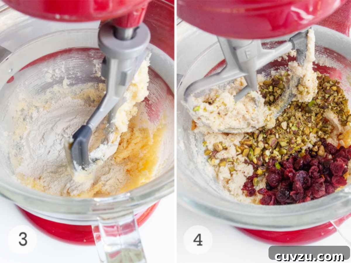 Jewel Toned Pistachio Cookies 6 The progression of cookie dough preparation: dry ingredients like flour and salt being gently mixed into the creamy base in a stand mixer, followed by the vibrant addition of dried cranberries and chopped pistachios, thoroughly incorporated to create a colorful, textured dough.