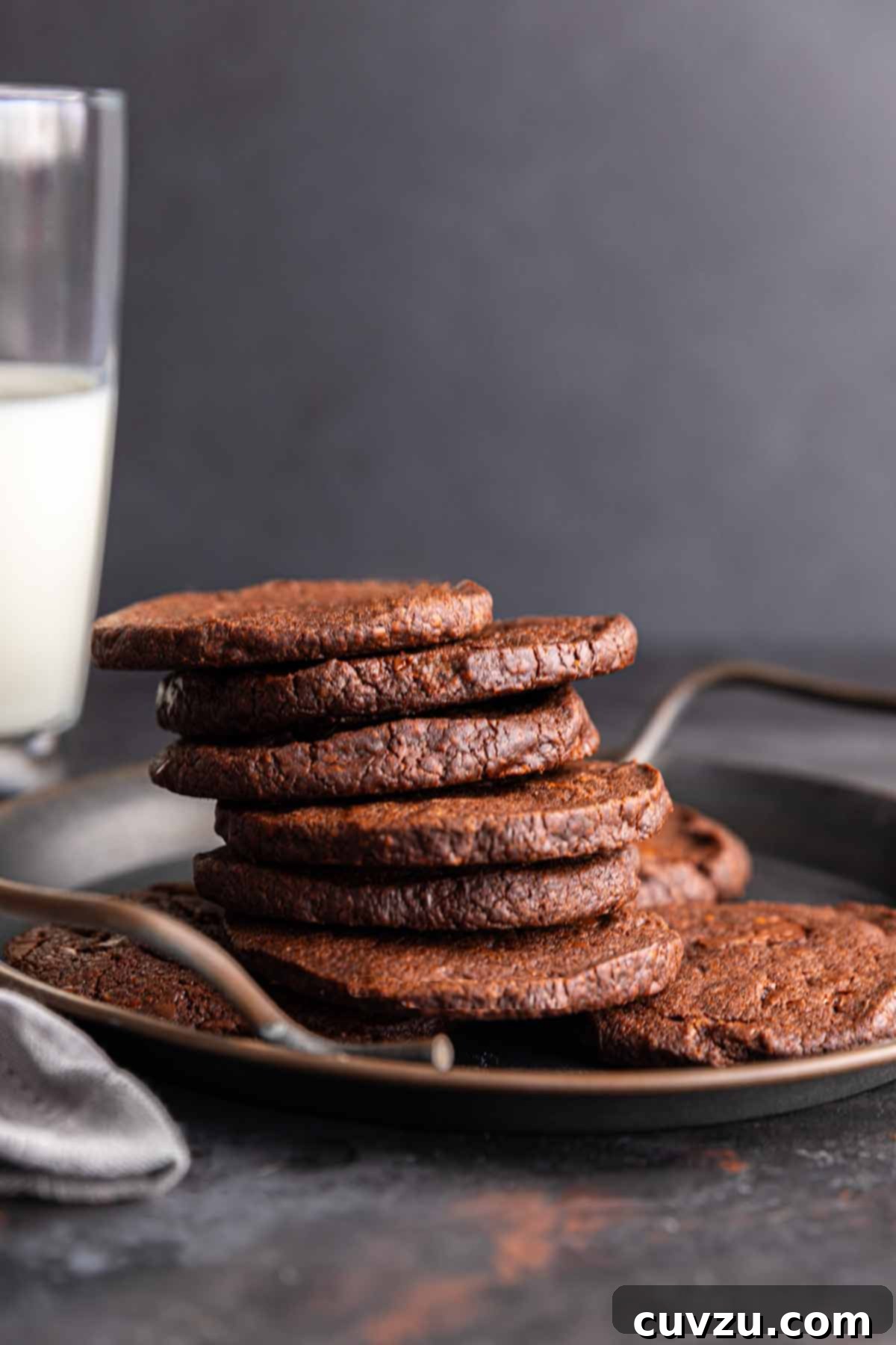 Rich Chocolate Espresso Shortbread 10 A metal tray with a pile of chocolate espresso shortbread cookies on it. Nearby, a glass of milk.