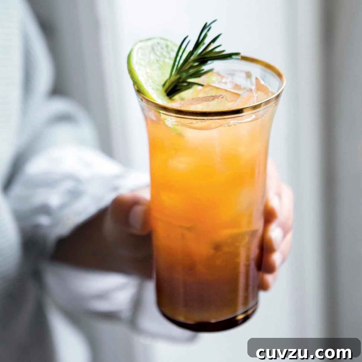 A tall cool glass of a winter mojito made with rum and a sugar syrup of rosemary, thyme, sage leaves.