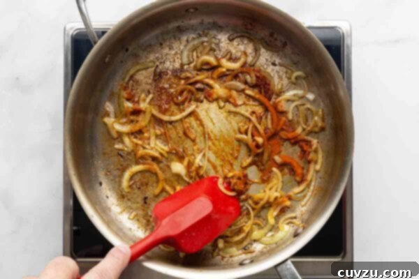 Velvety Meatball Stroganoff 14 A person sautéing onions in a skillet.