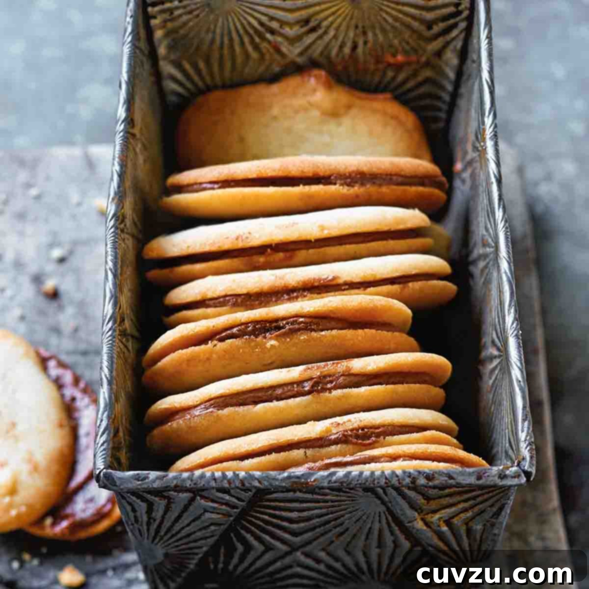 Eight homemade Milano cookies in a metal loaf tin.