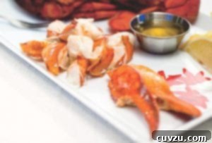 A close-up image of a perfectly steamed lobster served with a rich, golden drawn butter, highlighting its delicious components.