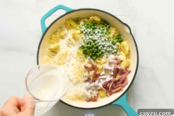 Creamy One-Pan Prosciutto Pea Tortellini 13 Tortellini, peas, cheese, and prosciutto being combined in a skillet.