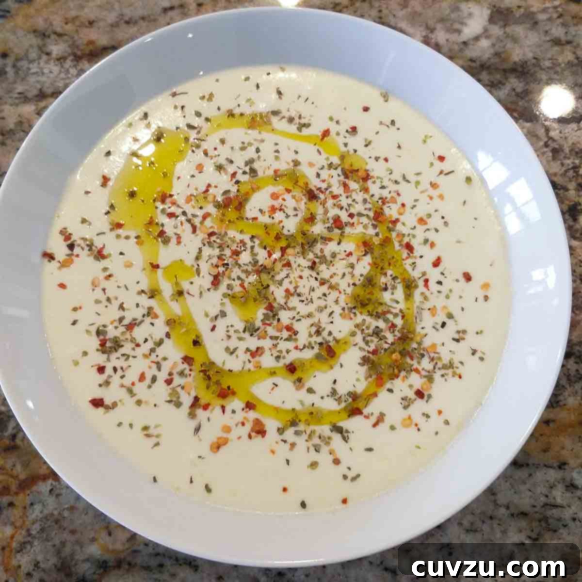 Creamy Whipped Feta 16 A white bowl filled with feta dip drizzled with oil and topped with spices.
