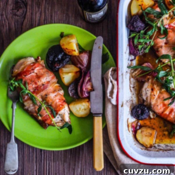 A green plate topped with a chicken breast stuffed with fresh figs and goat cheese and some roasted root vegetables alongside.