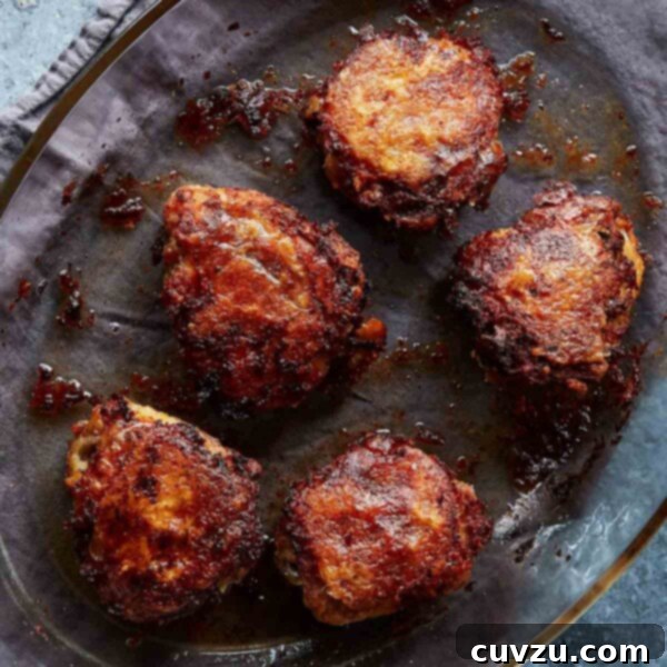 Four pieces of Judy Hesser's oven-fried chicken in a oval glass baking dish on top of a linen cloth.