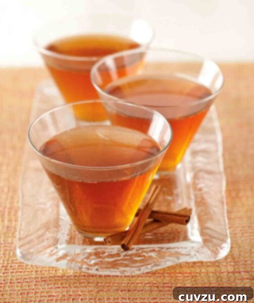 Autumn Ember 4 Three glasses of Maple Leaf Cocktails on a glass tray with cinnamon sticks, a festive and inviting autumn drink.