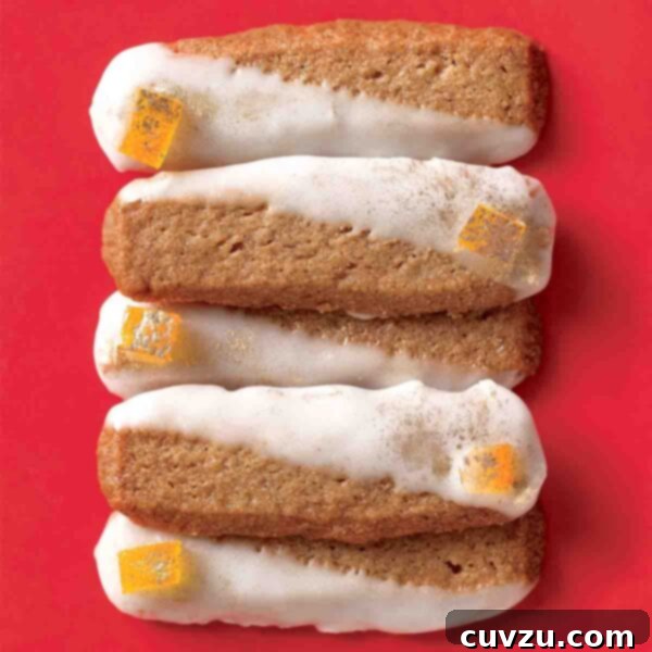 Pain d'Épices Cookies stacked in a pile of five glazed and garnished with candied orange peel.