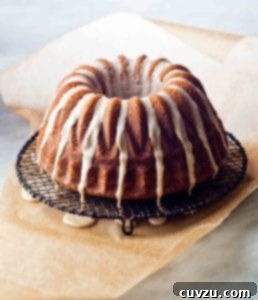 A close-up of a slice of espresso cake with a glistening coffee glaze, showing its moist and tender interior.