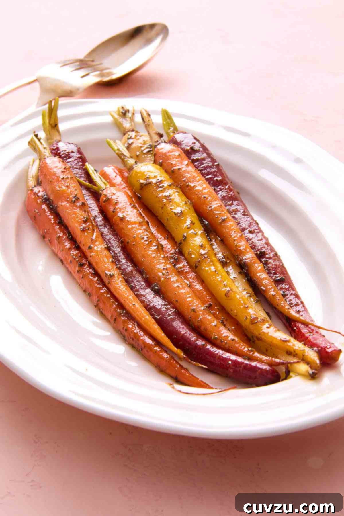 Slow-Simmered Orange Rosemary Carrots 8 A selection of colorful, glazed braised carrots artfully arranged on a white serving platter, ready to be enjoyed.