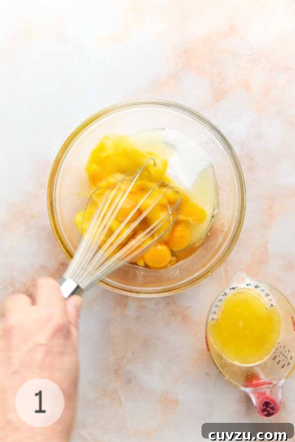 Meyer Lemon Curd: Zesty Citrus Delight 5 A bowl containing egg yolks, eggs, and sugar, being whisked together until light and frothy.