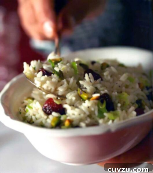 A close-up of the finished Rice Pilaf with Dried Cherries and Pistachios, garnished with fresh scallions.