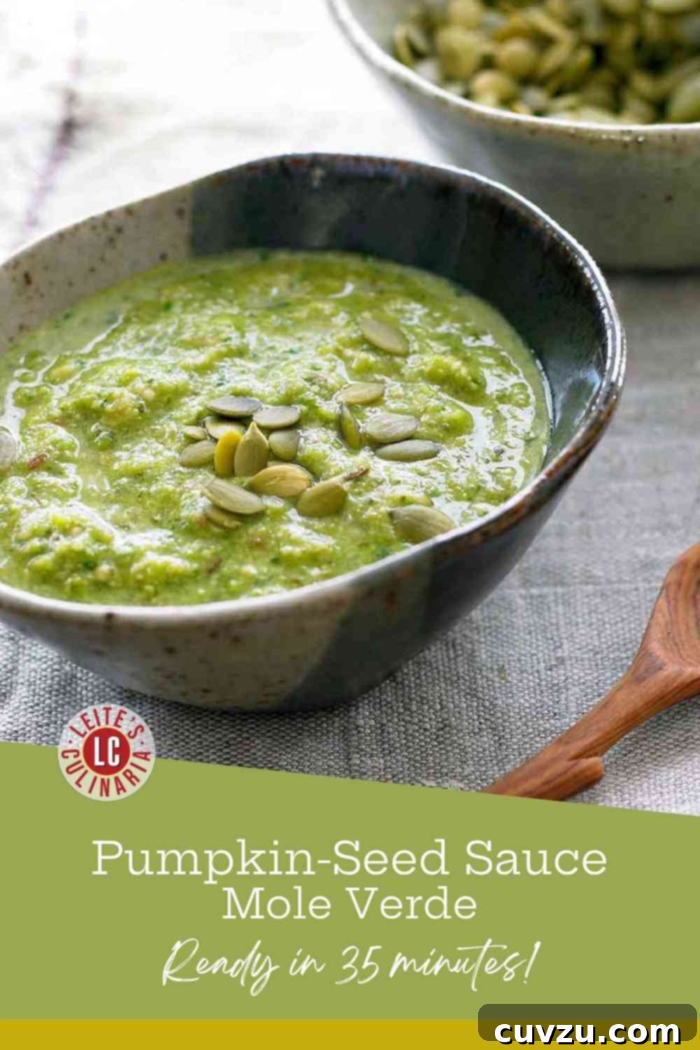 Pepita Green Mole 3 Close-up of vibrant green pumpkin seed mole with toasted pepitas, served in a small white bowl with a rustic spoon.