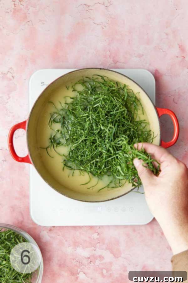 Caldo Verde: Portugal's Iconic Green Soup 11 A man's hand adding slivered collard greens or kale into a pot of smooth caldo verde soup base.