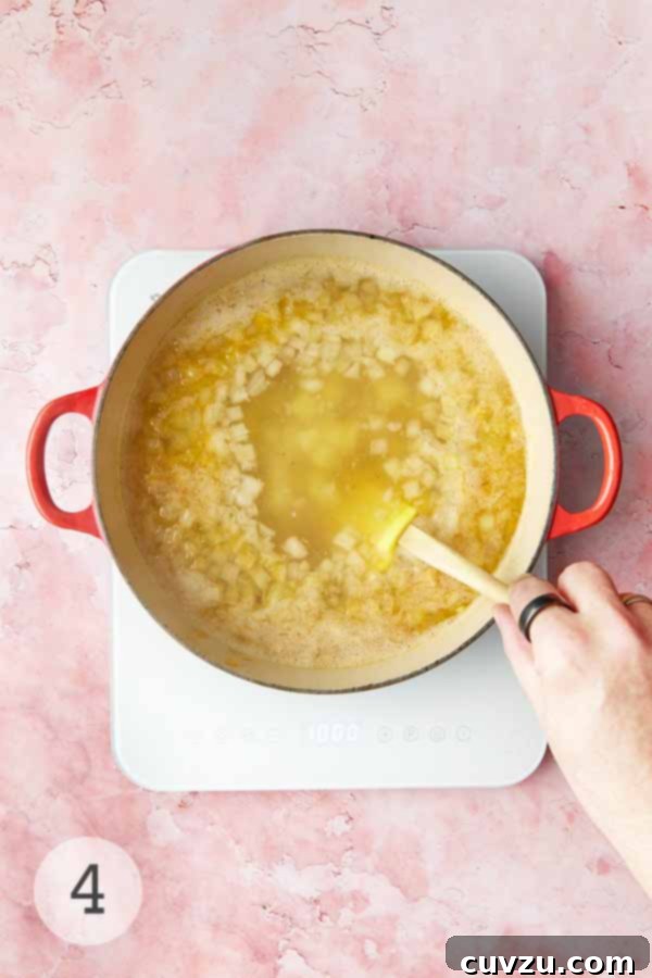 Caldo Verde: Portugal's Iconic Green Soup 9 A man's hand stirring a pot of simmering potatoes and aromatics for caldo verde.