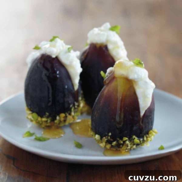 Three figs filled with ricotta cheese and topped with honey on a plate.