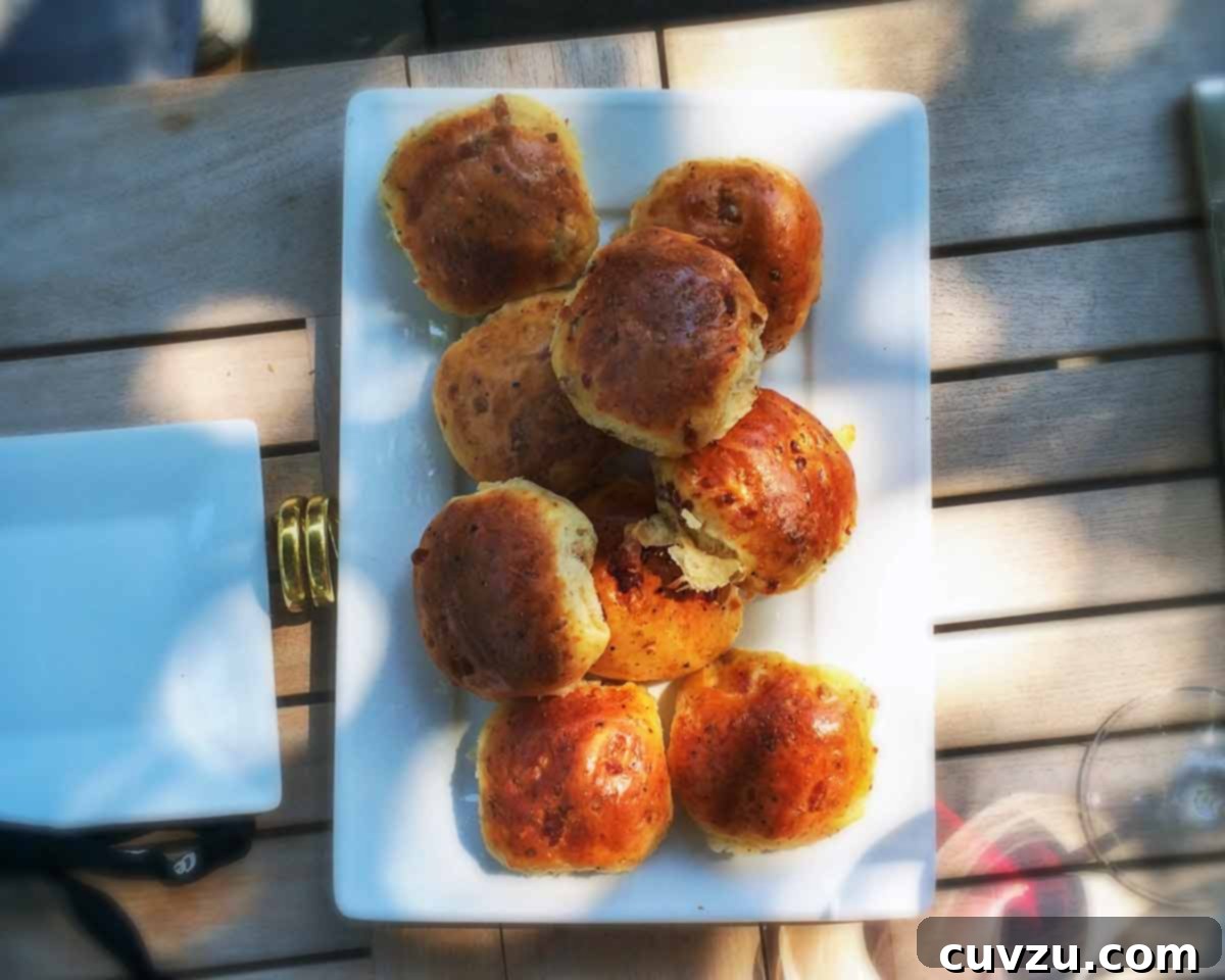 Golden Portuguese Bread with Sausage, Ham, and Melted Cheese 3 Portuguese presunto and cheese loaves on a white platter. A delicious savory bread.