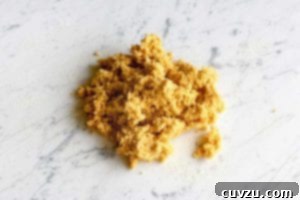 Golden Pumpkin Pasta Dough 6 A pile of rich orange pumpkin pasta dough resting on a white and grey marble surface.